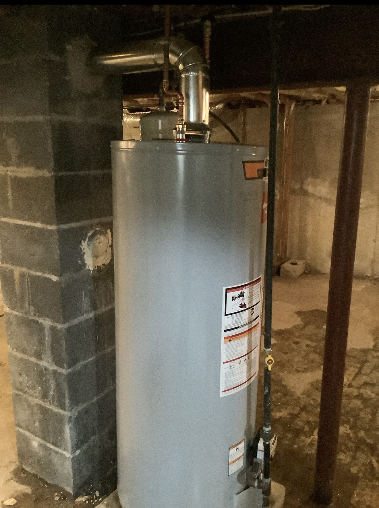 A-1 storage water heater installation beside a masonry chimney