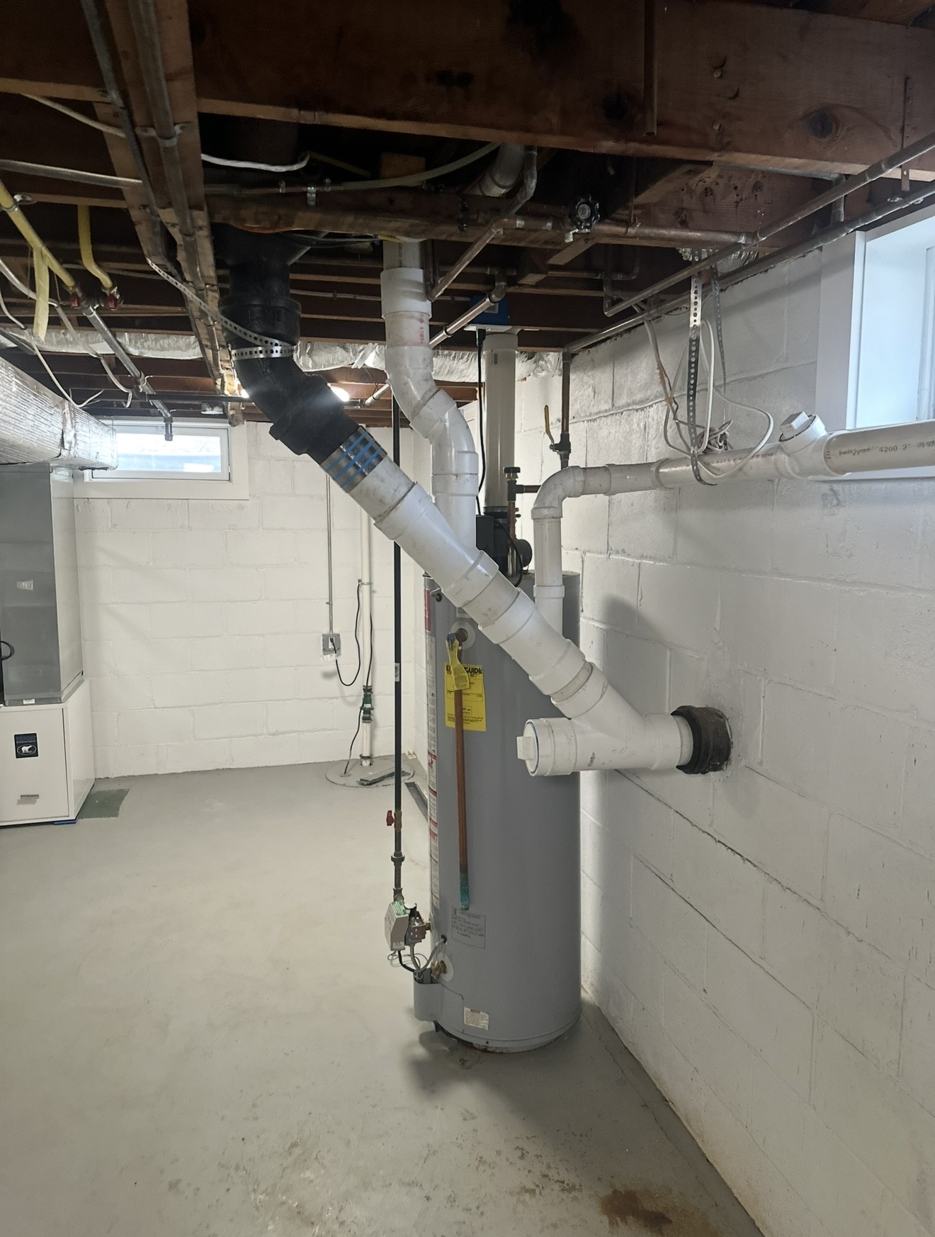 A-1 basement plumbing with drain piping and a water heater